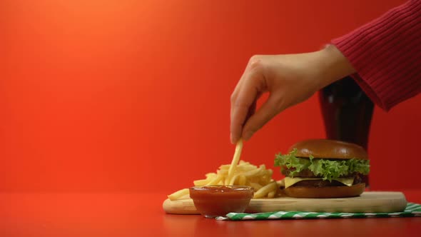 Customer Hand Taking Delicious French Fries With Sauce Rich in Calories Meal