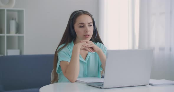 Female Operator In Call Center Work. Young Business Woman Wearing Headphones Communicating By Video