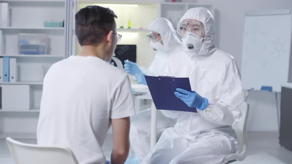 Doctor in Protective Suit Examining Contagious Patient