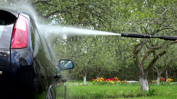 Washing Automobile Car with Strong Water Jet in Garden