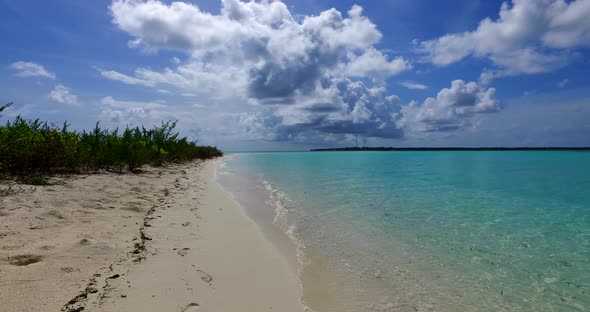 Wide above tourism shot of a white sand paradise beach and blue sea background in colorful 4K