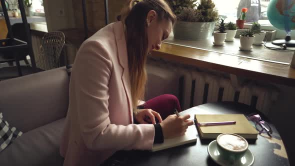 Businesswoman Working Remotely Talking on Mobile. Busy Businesswoman Working in a Cafe Talking on