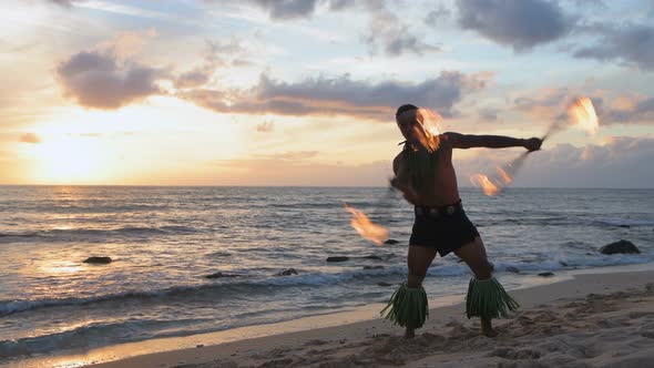 Fire juggler juggling fire sticks in the beach 