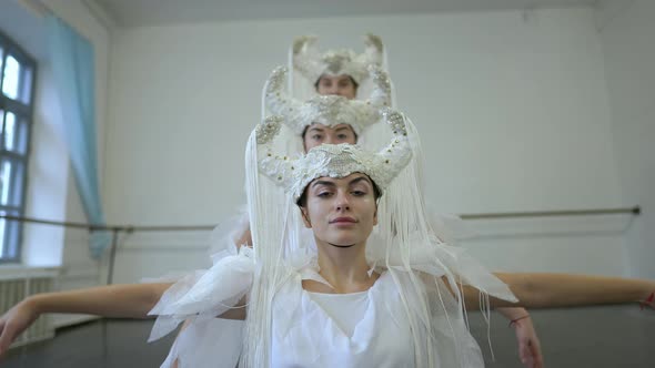 Portrait of Confident Young Beautiful Woman Moving in Slow Motion with Friends Dancing in White