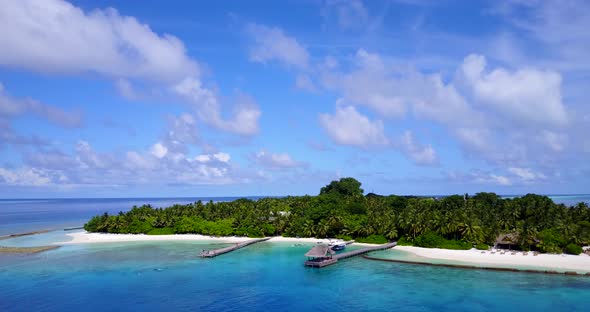 Wide angle overhead tourism shot of a sandy white paradise beach and blue water background 