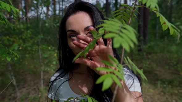 Woman Standing Next To a Tree in a Forest