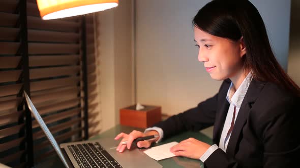 Businesswoman working at night inside office