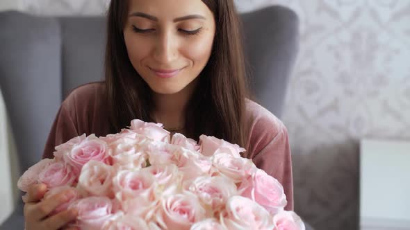 Happy Woman Look on Bouquet of Roses