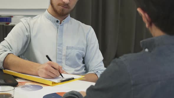 Handsome Businessman Taking Notes During Business Meeting