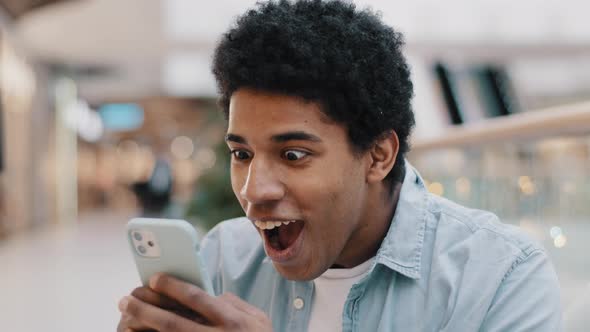 African American Guy Surprised By Message Received Wins Online Bets Looking at Mobile Phone Opens