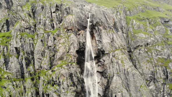 Aerial View Waterfall Flows Down From the Mountains Forming a Stream and Fog