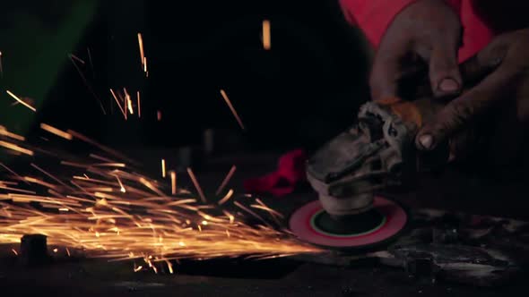 Professional mechanic is cutting steel metal.