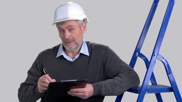 Portrait of Caucasian Foreman Writing on Clipboard.