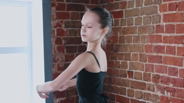 Ballet Dancing Indoors a Little Girl Dancing in Black Suit on Training From the Corner of the Studio