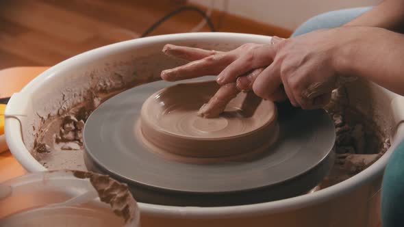 Pottery - Master with Finger Is Making the Bottom for a Clay Bowl on the Potter's Wheel