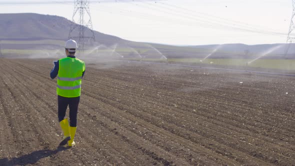 Engineer works with tablet in farmland.