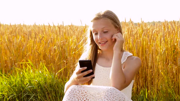 Happy Young Girl with Smartphone on Cereal Field