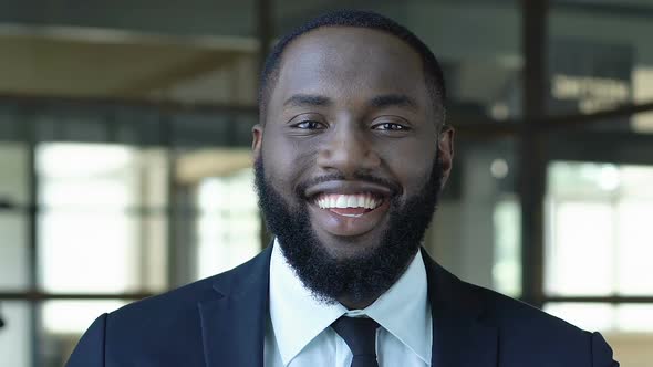 Happy African American Male Employee Laughing Into Camera, Satisfied With Job