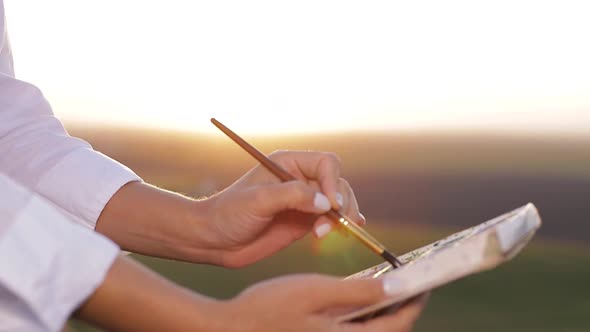 Young girl artist who paints a picture of nature.