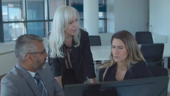 Leader Watching and Discussing Presentation with Her Team