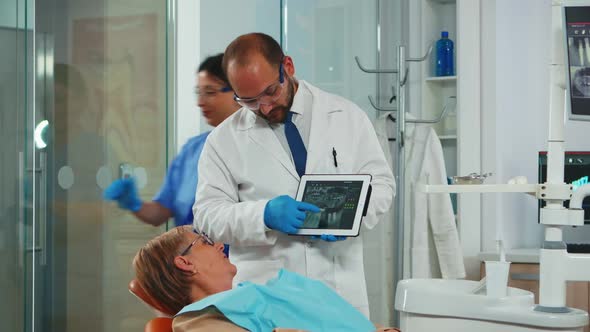 Orthodontist Using Tablet to Explain Dental Xrays to Patient