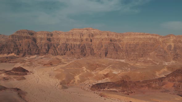 Slow backwards moving shot of a beautiful big desert canyon filmed with a drone, great for transitio