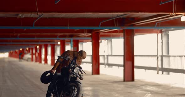 Man Sits on a Motorcycle in a Large Garage