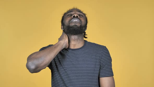 Casual African Man with Neck Pain Yellow Background