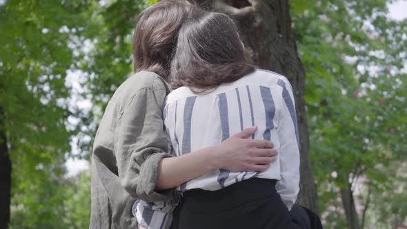 Back View of a Young Happy Couple in Casual Clothes Spending Time Together in the Park