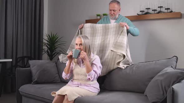 Elderly Grayhaired Man Covers His Wife with a Blanket Taking Care of Their Loved Ones Adult People