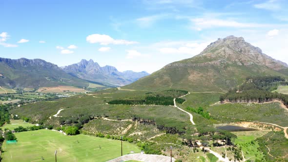 Aerial drone, Stellenbosch university outdoor sports complex and stadium, mountain slope, green fiel