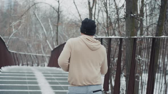 Slow Motion Man Jogging on Bridge in Winter