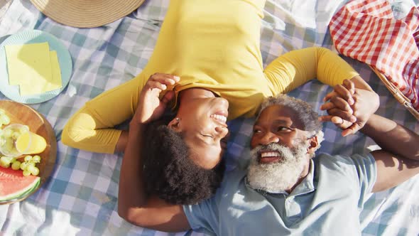 Happy african american couple having picnic on sunny beach