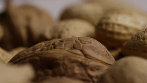 Cinematic, rotating shot of a variety of nuts on a white surface - NUTS MIXED 038