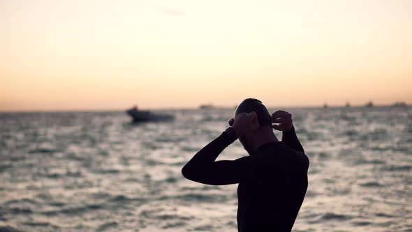 Professional Triathlete Swimming In Goggles Workout On Sea. Professional Swimmer Stretching Warm Up.