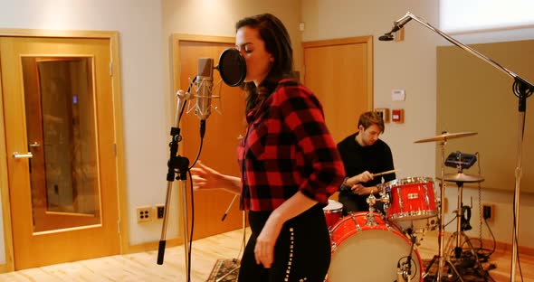 Woman singing in recording studio