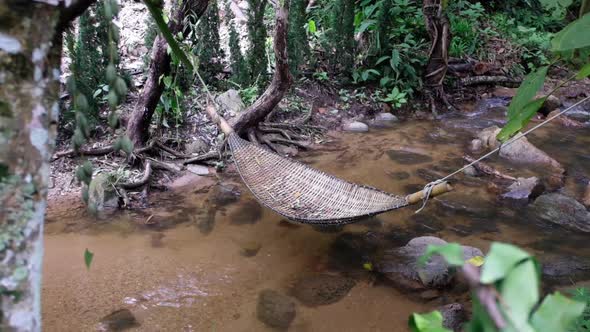 Slow motion of a wooden hammock in the waterfall