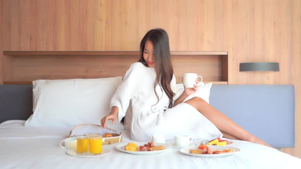 Young asian woman breakfast on bed