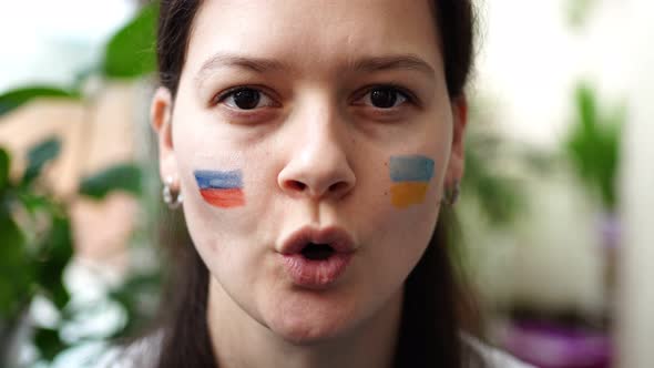 Young RussianUkrainian Girl with the Flag of Ukraine and Russia on Her Face is Saying STOP PUTIN