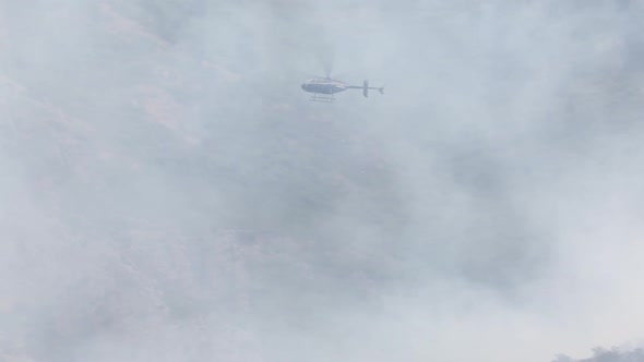 Helicopter flying through smoke of wildfire