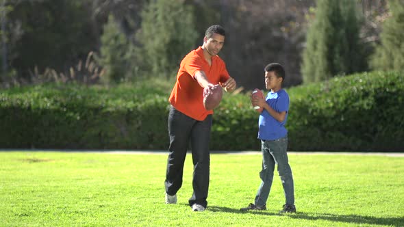 A father teaching his sons how to play American football.