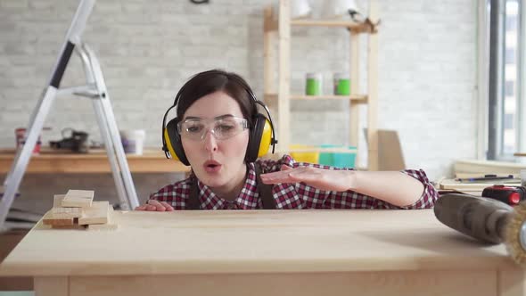 Closeup Young Professional Carpenter Woman Blows Wood Shavings From the Tableslow Mo