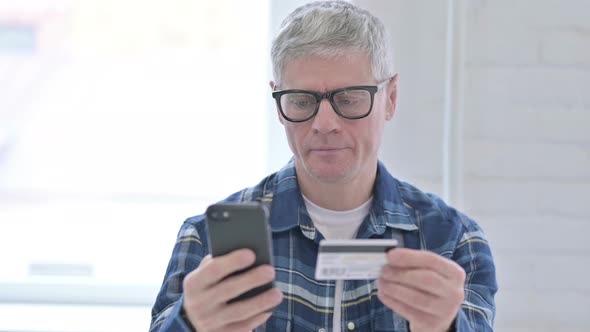 Portrait of Casual Middle Aged Man Making Online Payment on Smartphone 