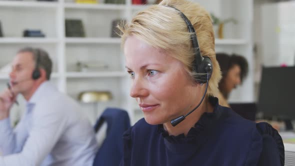 Woman talking at a customer with headphone