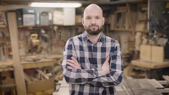 A Brutal and Bald Man in a Carpentry Workshop