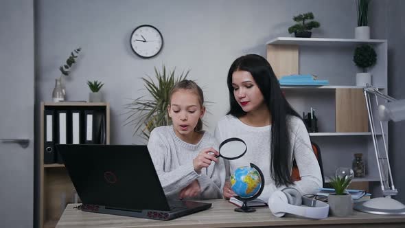 35-Aged Woman which Helping to do Geography Hometask Together with Her Teen Daughter