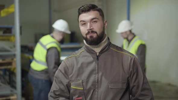 Portrait of Young Handsome Caucasian Man Looking Back at His Colleagues, Turning To Camera and