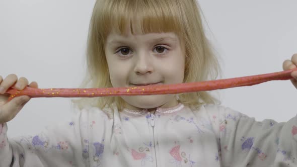 Kid Playing with Hand Made Toy Slime. Child Having Fun Making Red Slime