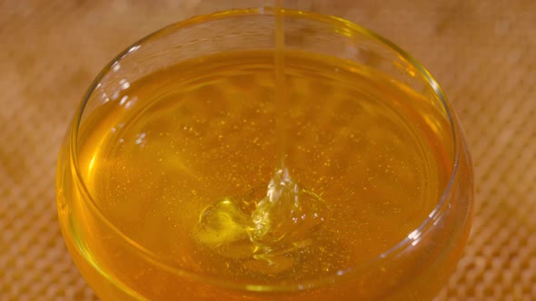 Honey Dripping Falling Into a Glass Bowl