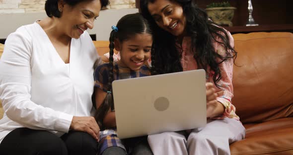 Multi-generation family using laptop in living room 4k